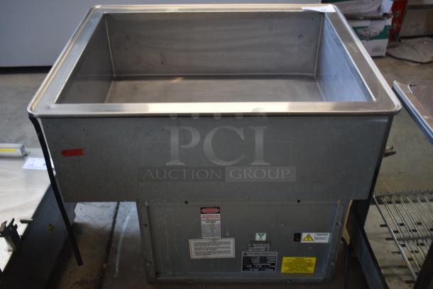 Stainless steel sink with attached base, industrial use, visible caution and instruction labels, good condition.