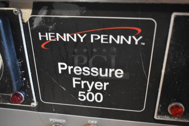 Henny Penny Pressure Fryer 500, visibly used, showing signs of wear. Black label with white text detailing model name.