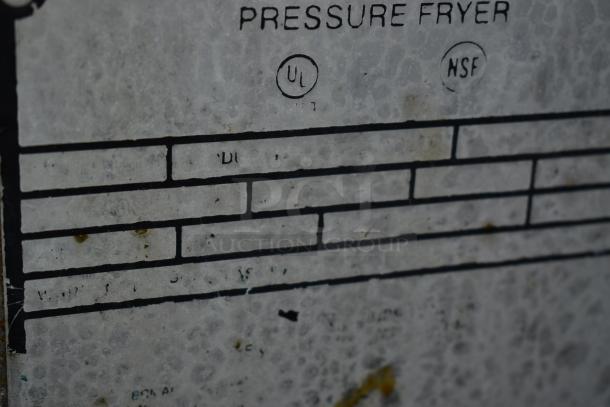 Close-up of a pressure fryer label with UL and NSF certification marks, showing signs of wear and faded text.
