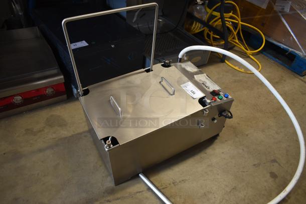 Stainless steel floor cleaning machine with handles, control buttons, and attached hose. Label reads "Lot 101." In good condition.