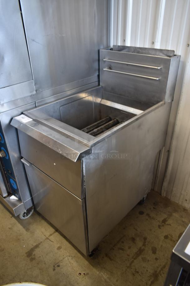 Commercial stainless steel deep fryer in used condition; features dual basket slots and temperature controls, ideal for kitchens.