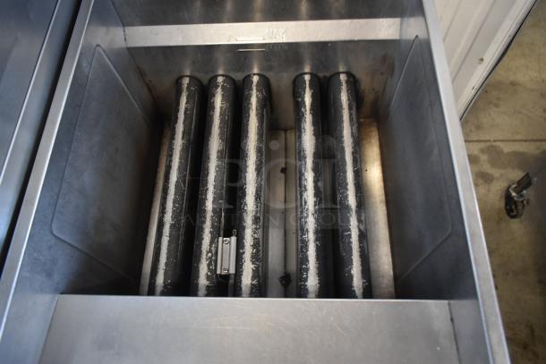 Industrial fryer with five heating elements in stainless steel housing, showing wear. Max/Min level markings evident.