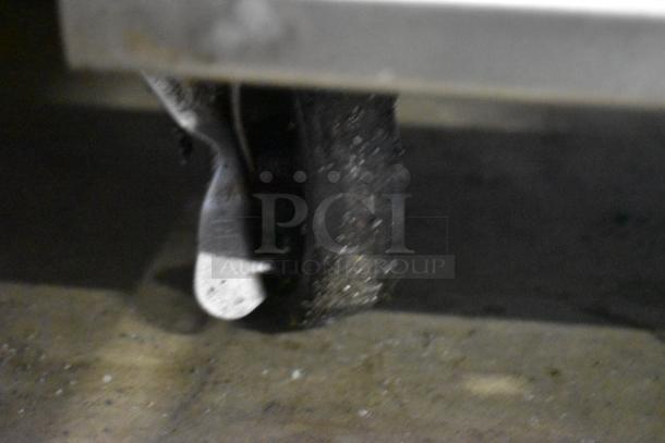 Blurred close-up of a worn caster wheel attached to a metal object. Wheel shows signs of use and dirt accumulation.