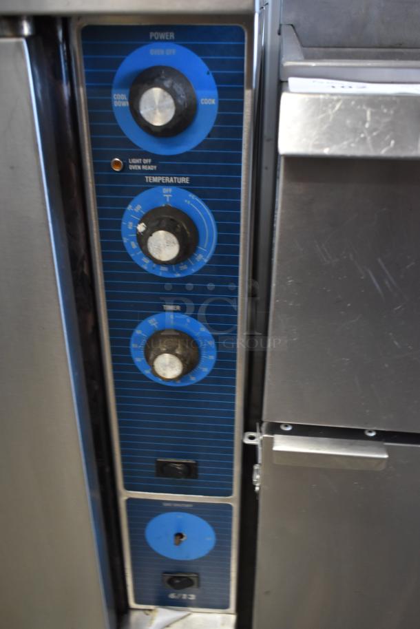 Commercial oven control panel with power, temperature, and timer dials. Markings indicate cool down and oven ready.