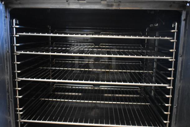 Commercial oven interior, five metal racks, stainless steel, spacious design, clean condition, ideal for bakery use.