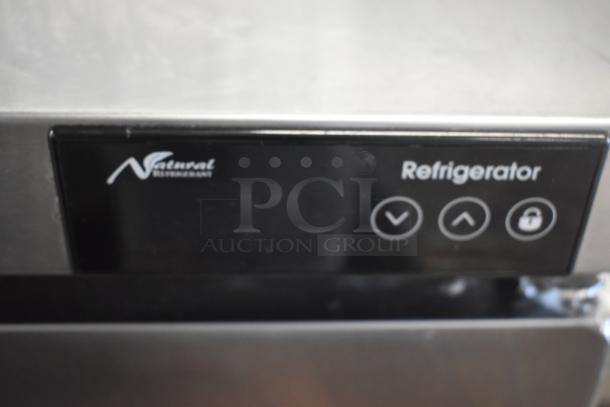 Stainless steel refrigerator panel with natural refrigerant logo, arrow controls, and a lock icon, in good condition.