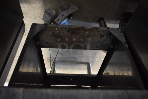 Rusty metal industrial machine frame with bolts and wires, showing signs of wear and possible corrosion damage.
