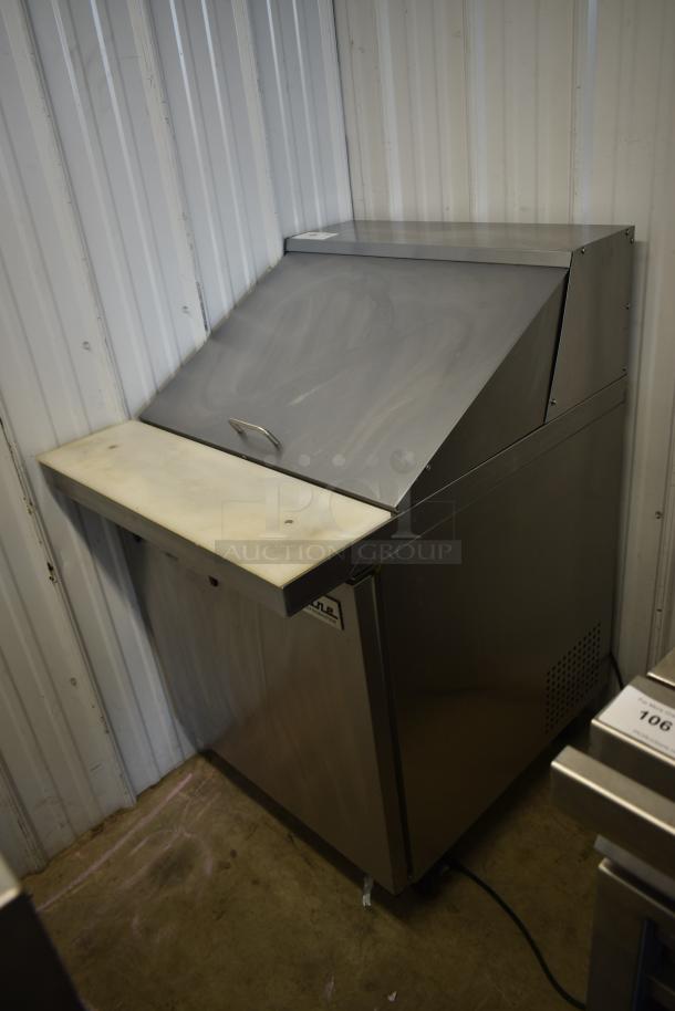 Stainless steel commercial food prep station with cutting board, used condition, visible wear, labeled "Nugent Franklin."