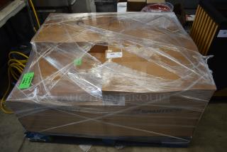 Large cardboard box on a pallet, wrapped in plastic, labeled "Canon Toner Com" and "Spartech." Tags indicate auction lot 109.