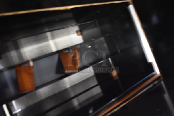 Blurry image of a dark wood object with reflective surfaces and wooden elements, condition unclear.