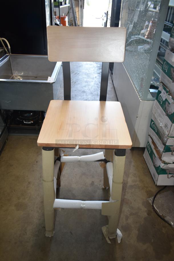Wooden high chair with metal frame, new condition, protective wrapping on legs, simple modern design, ideal for bar use.