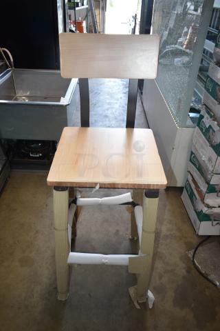 Wooden high chair with metal frame, new condition, protective wrapping on legs, simple modern design, ideal for bar use.