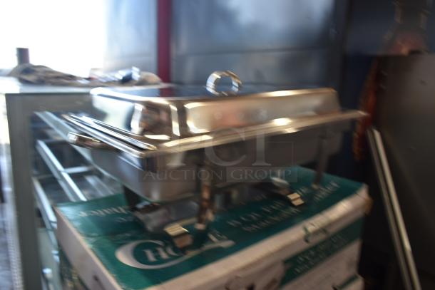 Stainless steel chafing dish with lid on top of original packaging, in excellent condition, labeled "Choice."
