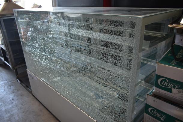 Glass display case with damaged, cracked front panel. Multiple shelves inside. Fair condition, needs repair.