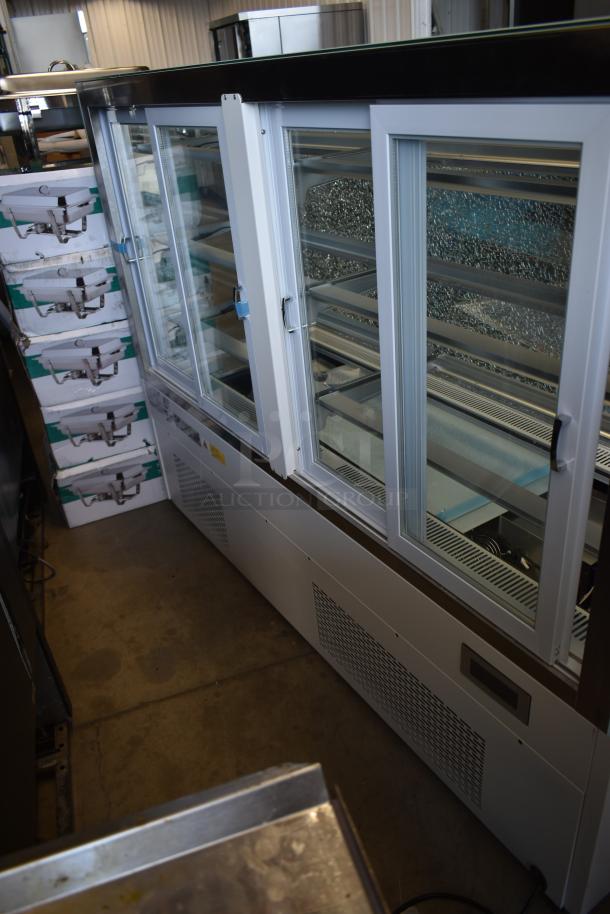 Large commercial glass display freezer, white frame, sliding doors, multiple shelves, in good condition. Ideal for retail.