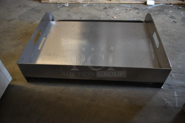 Large metal tray with side handles, industrial-style, in good condition, suitable for storage or serving purposes.