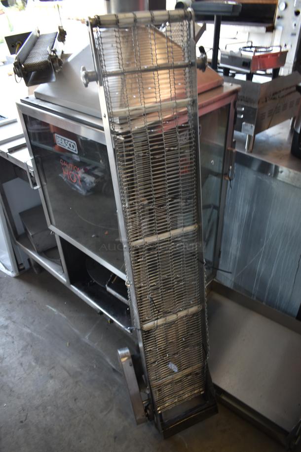 Commercial rotisserie oven with metal racks, BE&SCO brand, labeled "Caution Hot," stainless steel finish, industrial condition.