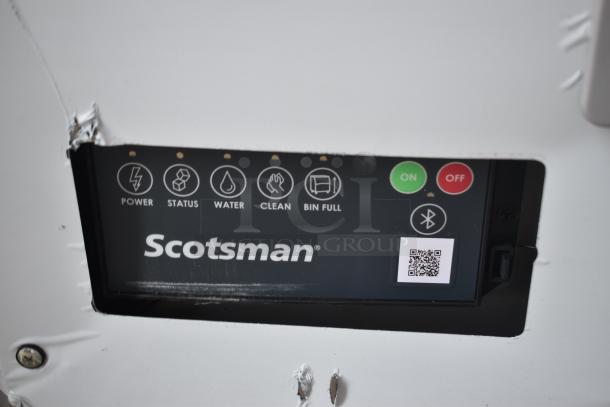 Scotsman ice machine control panel, displaying power, status, and bin full indicators, with QR code and Bluetooth symbol.