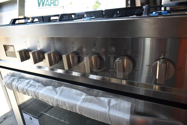 Stainless steel oven with five control knobs and protected handle, displaying temperature and function markings.