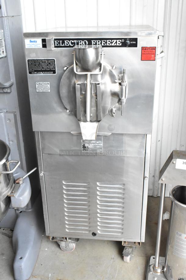 Electro Freeze FT-1 stainless steel commercial batch freezer on casters; 230V, 1 phase; caution and operation labels visible.