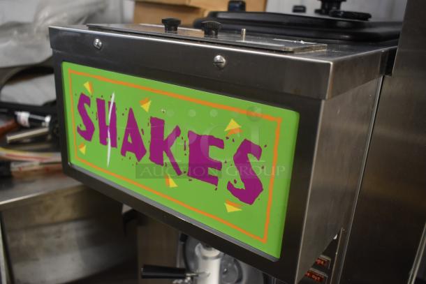 Commercial shake machine in stainless steel, featuring a colorful "SHAKES" sign. Suitable for high-volume use.