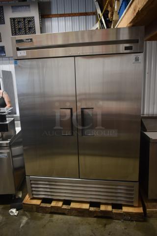 True stainless steel double-door commercial refrigerator on a pallet; model T-49, excellent condition, energy-efficient.