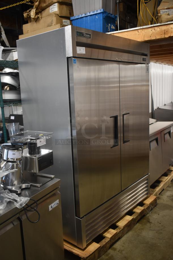 True stainless steel commercial refrigerator, double-door, in good condition, with label indicating energy efficiency.