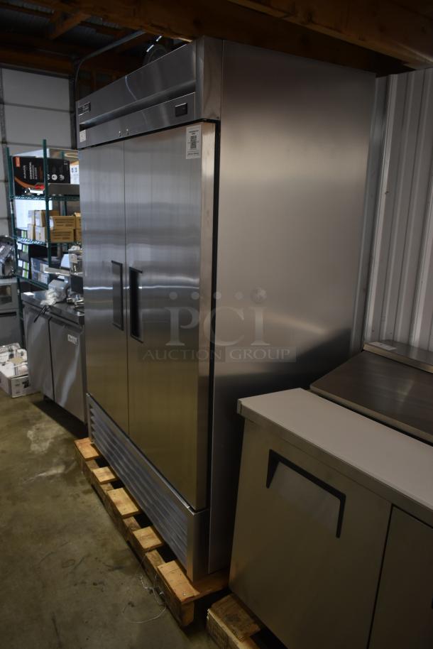 Stainless steel commercial refrigerator, double doors, excellent condition, energy-efficient label visible, on wooden pallet.