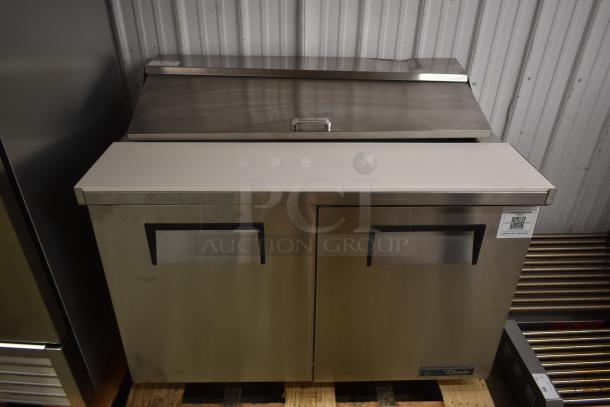 True two-door stainless steel refrigeration unit with closed lid, in sturdy condition. QR code tag on front.