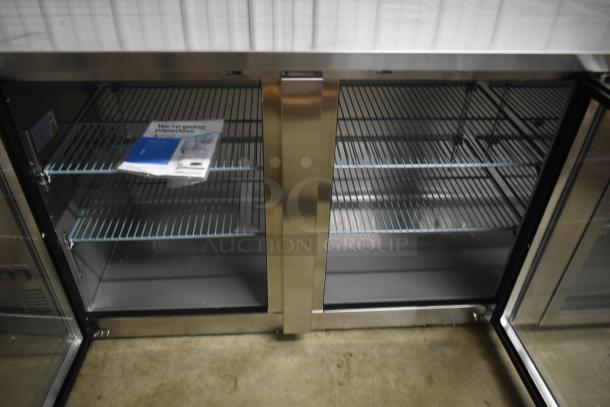 Commercial stainless steel refrigerator with double glass doors and wire shelving. Manual included. Good condition.