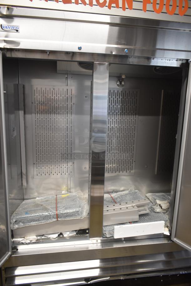 Commercial stainless steel warming cabinet by Avantco, interior shelves wrapped in bubble wrap. Upper sign reads "American Food."