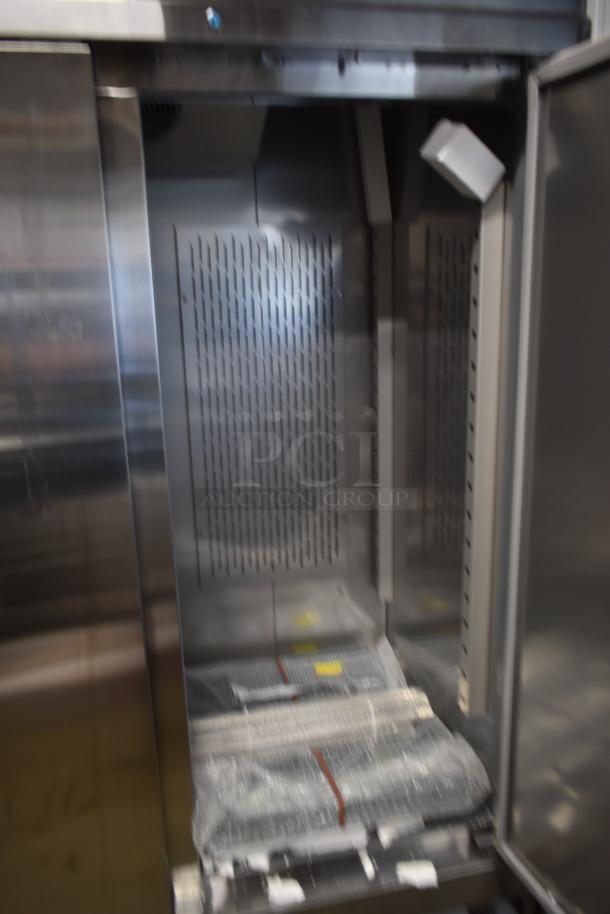 Stainless steel commercial refrigerator with open door, showing interior shelves, venting, and packaging. Item appears new.