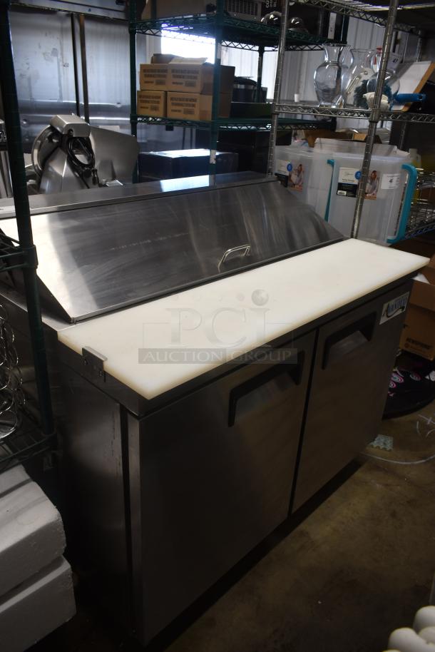 Stainless steel refrigerated prep table with dual doors, cutting board top, and handle, in good condition.