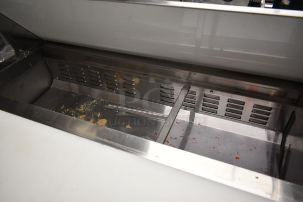 Stainless steel cold prep table, used, minor surface debris, clean interior, suitable for commercial kitchen use.