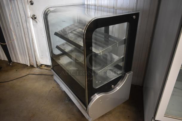 Glass-front refrigerated display case with three metal shelves, used condition, silver frame, ideal for showcasing food items.