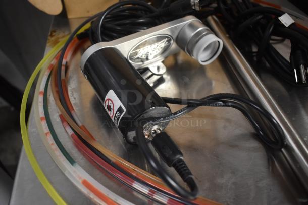 Electric motor with attached cables on metal surface, features brand logo and "DO NOT ROTATE" label. Multicolored tubing included.