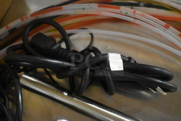 Coiled black power cable with a visible label indicating "10A 125V", in good condition.