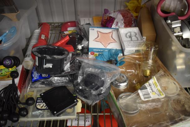 Assorted hardware items and accessories, including light bulbs, star-shaped cake pan, and miscellaneous tools in storage.