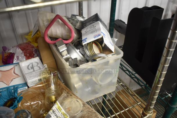 Plastic bin with various metal cookie cutters, jar lids, a heart-shaped handle tool, and miscellaneous items.