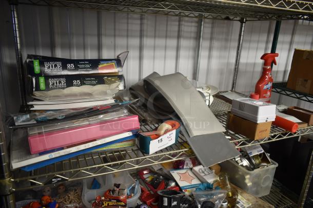 Metal shelf with assorted office supplies, hanging file folders, Scotch tape dispenser, cleaning spray, and miscellaneous items.