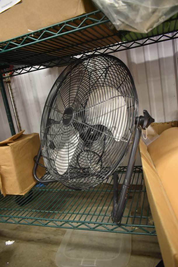 Industrial floor fan with metal blades and protective grill, "Commercial Electric" label, adjustable stand, good condition.