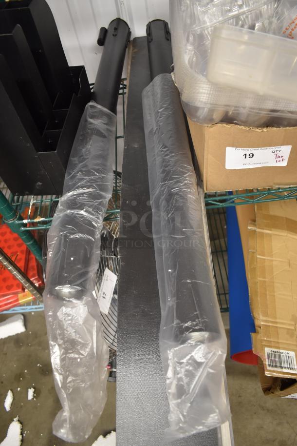 Two wrapped black metal poles on a storage shelf, adjacent to a box labeled "PCI Auctions Lot 19."