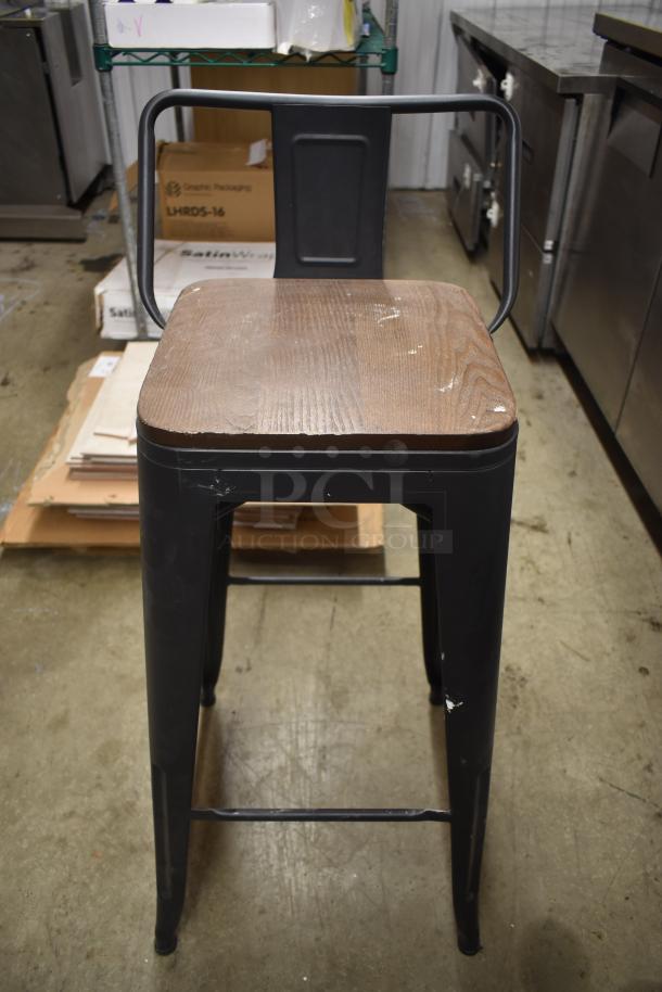 Industrial-style metal bar stool with wooden seat, black frame, scuffs and signs of wear, sturdy design, 30" height.