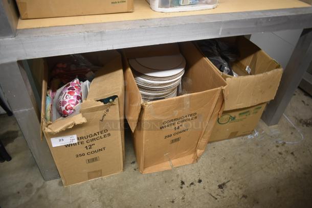 Three boxes of corrugated white circles, sizes 12" and 14", total 750 count, in good condition, on a metal shelf.