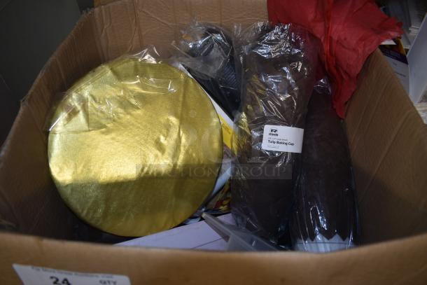 Box of assorted baking supplies, featuring a gold cake board and packages of brown tulip baking cups.