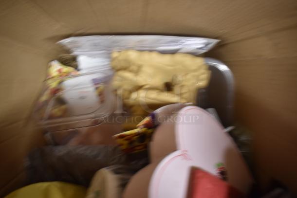 Blurred image of assorted items in a cardboard box, including a plastic container, beige foam, and a round object with red markings.