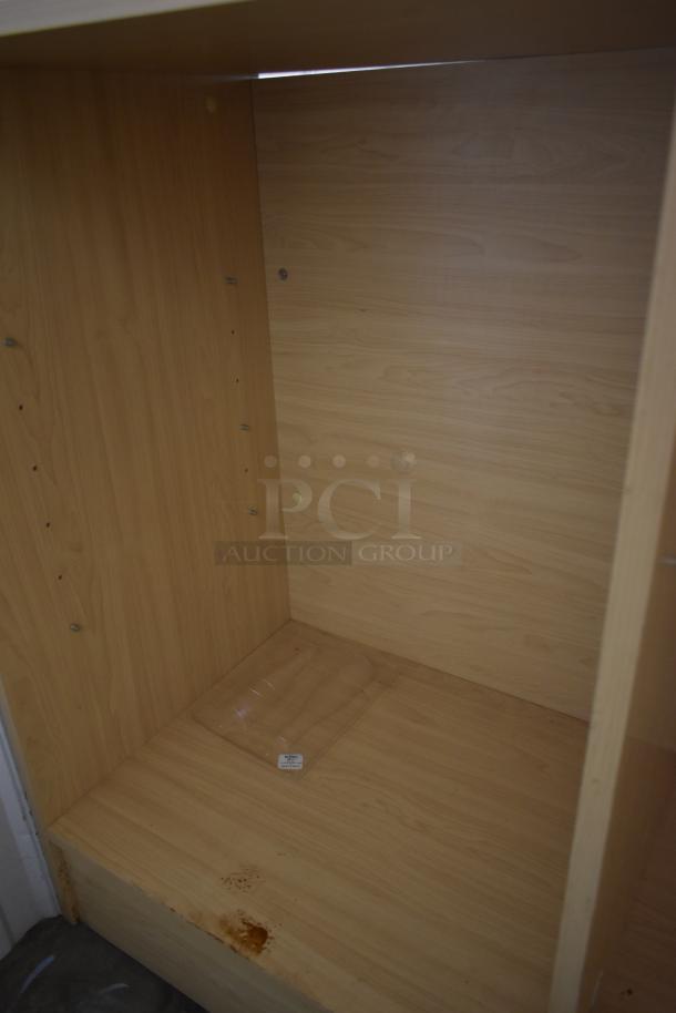 Empty wooden cabinet with adjustable shelves, light wood finish, visible stains on the bottom. Minimal wear, no labels.
