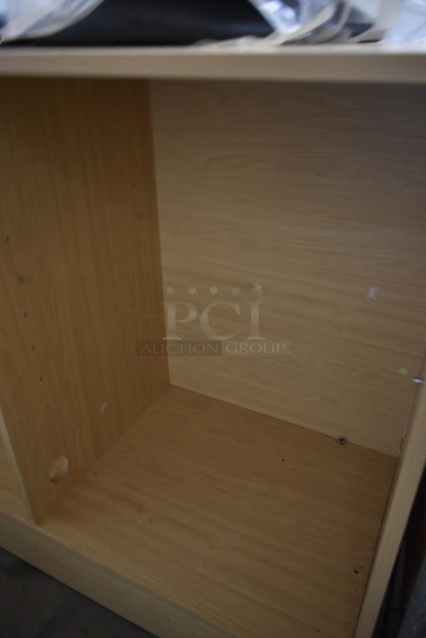 Empty wooden cabinet with light wood grain finish, visible shelf holes. Good condition. No labels or markings.