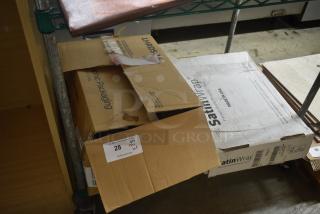 Open cardboard boxes on a shelf, with visible labels. One box marked "SatinWrap" contains wrapping tissue. Auction tag with "28."