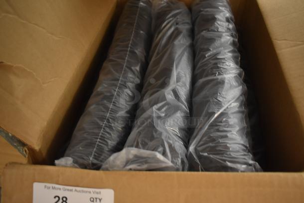 Box with three plastic-wrapped black items, condition unknown, label reads "28 QTY" with auction visit info.
